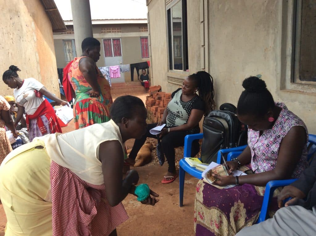 A JumpStart Africa group meeting in progress, members seated together with cash and record books in hand.