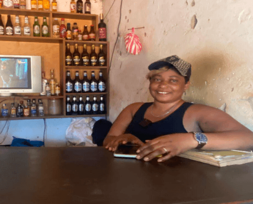 Nayiga Evelyn behind the counter of her bar and pool table business in Kampala.